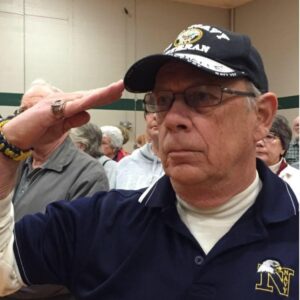 Veteran saluting indoors at community gathering