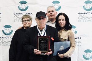 Bill Leonard holding his Spirit of St. Louis award plaque with three companions